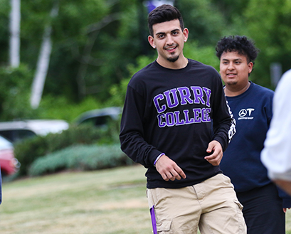 A male student smiles at the camera while at Orientation 