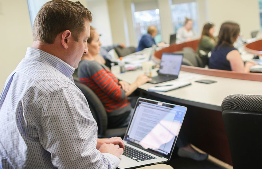An adult learner in class pursuing an Accounting degree from Curry College