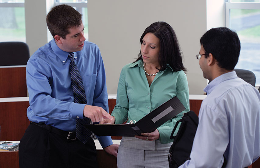 Curry College continuing education students collaborating in class while pursuing a business management degree