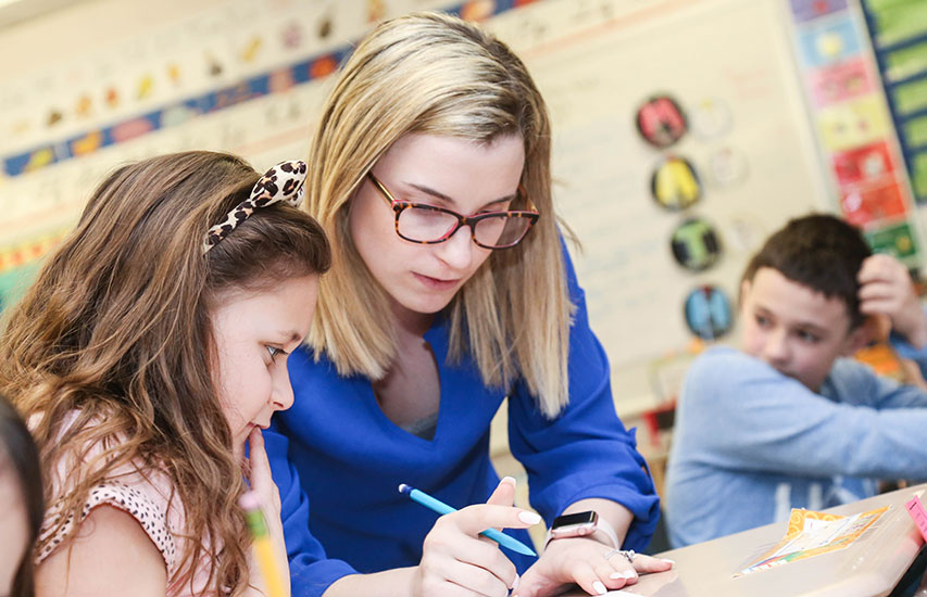 The Education 2nd Teaching License Post Master's at Curry College is represented by an alumna teaching young students