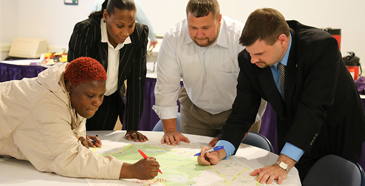 Students in class collaborate on a project while pursuing a Curry College Master of Arts in Criminal Justice Degree