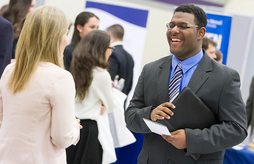 Curry College student pursuing a Business Management degree networking with employer