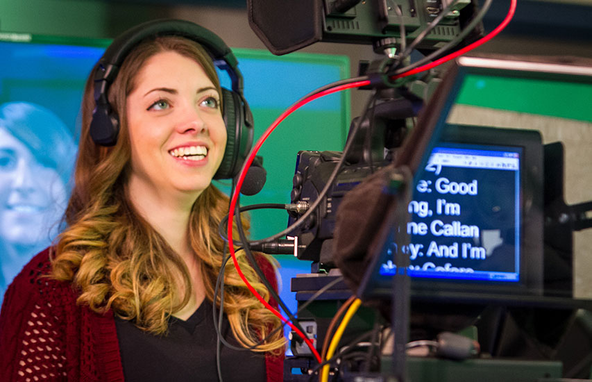 A student manning a studio camera pursuing a Communication degree from Curry College