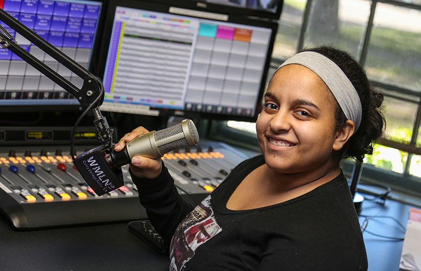 Student pursuing a radio/audio production concentration in the WMLN studios at Curry College