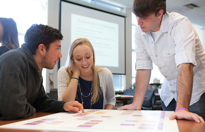 Students collaborating on a class project representing the Curry College 5th Year M.Ed. degree