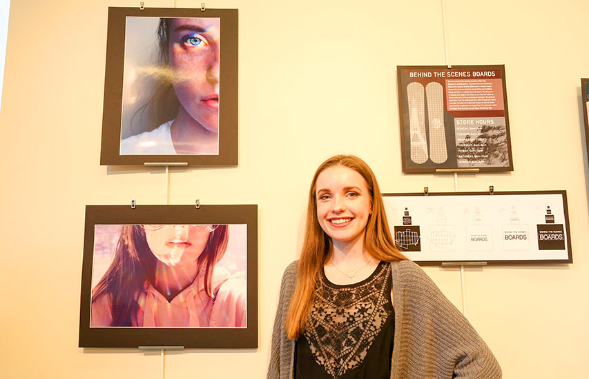 A student shows off her portfolio from pursuing a Design degree from Curry College