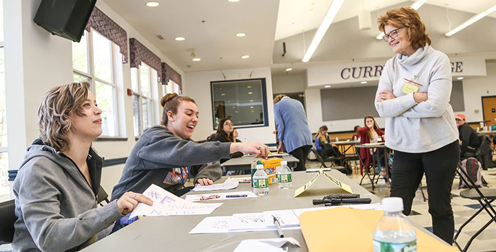 Students pursuing a Community Health and Wellness Degree at Curry College consult with a faculty member