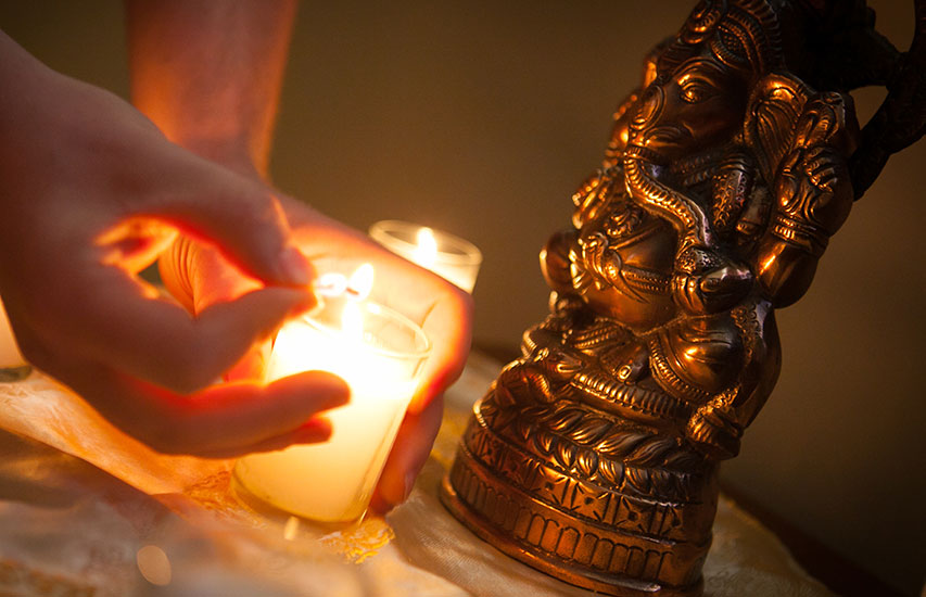Student lighting a candle representing the Asian Studies minor at Curry College