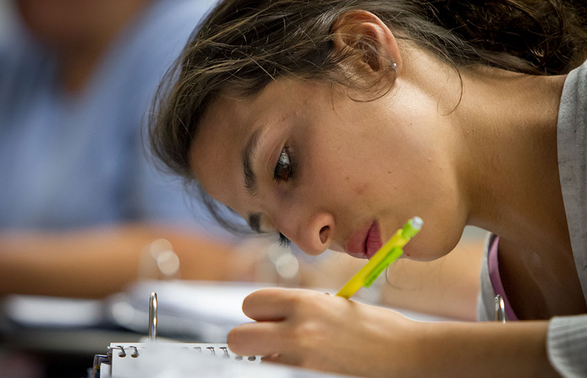 A student in the Writing Program takes notes in class