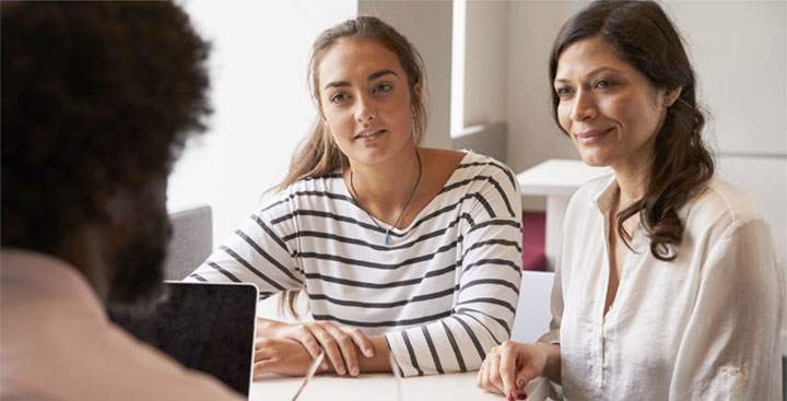 A mother and daughter discuss affordability with a counselor