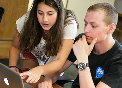 Students collaborating at a laptop on how to Apply online to Curry College