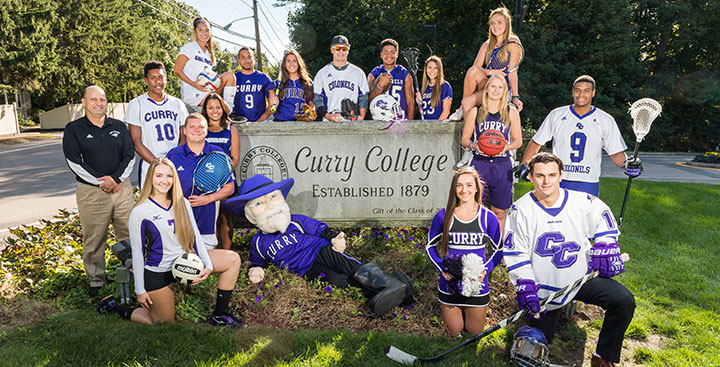 Curry College student-athletes pose at the front gate for a photo