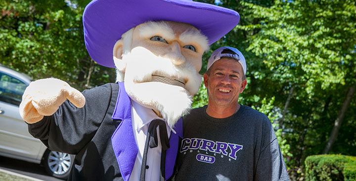 A Curry College Dad poses for a photo with the Colonel mascot