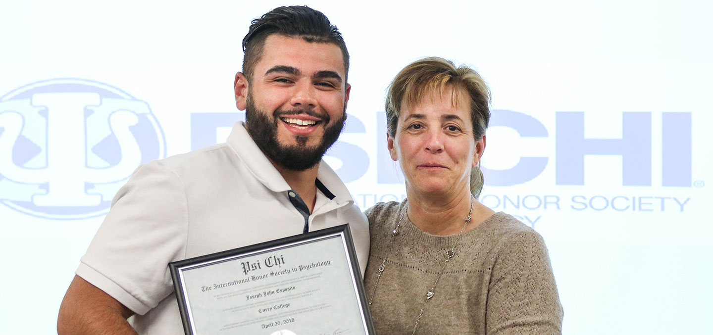 Psi Chi member poses with certificate and faculty