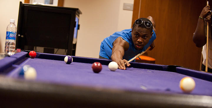 A student playing pool in the Billiards Room